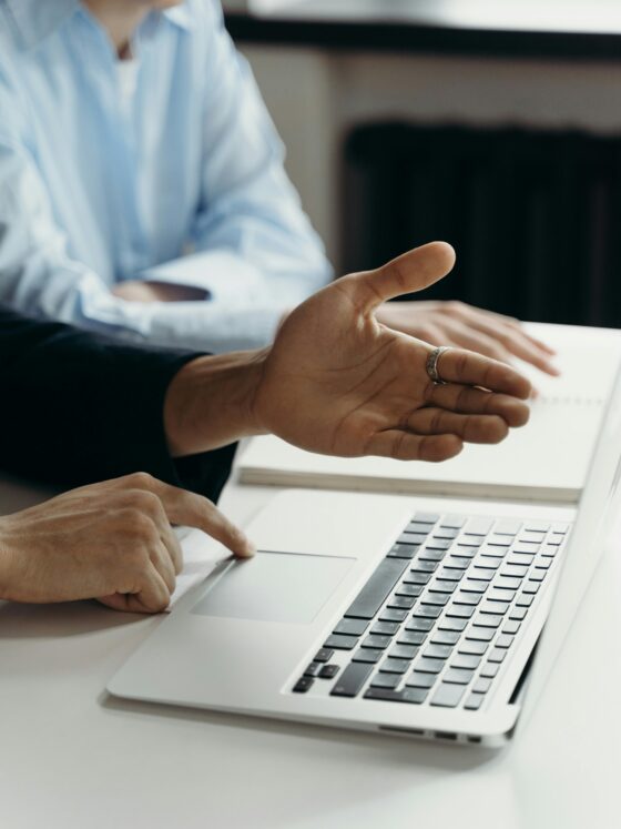 Two people discuss by laptop